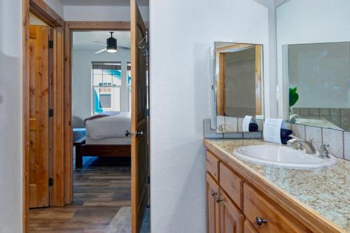 a bathroom with a sink and a mirror and a bedroom at Fox Pointe Condo by Park City Vacations in Park City