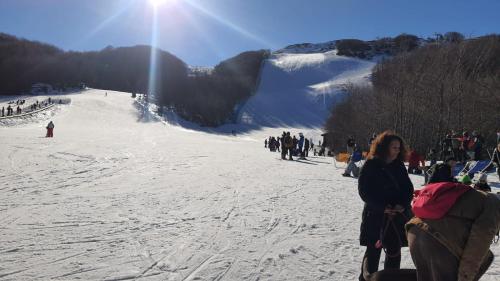 a group of people skiing down a snow covered slope at Hotel Veles in Querciola