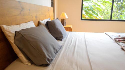a bedroom with a white bed with pillows at House 15 Min From The Beach With River Access in Ojochal