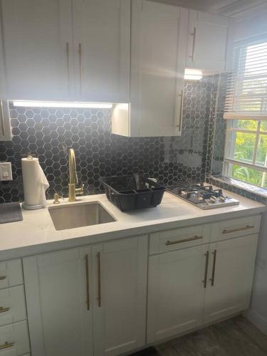 a kitchen with white cabinets and a sink at Idyllic escape in Mandeville