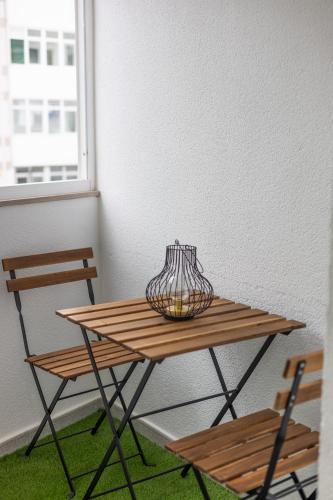a table with a vase on top of it next to two chairs at Apartamento Ronda Muralla in Lugo