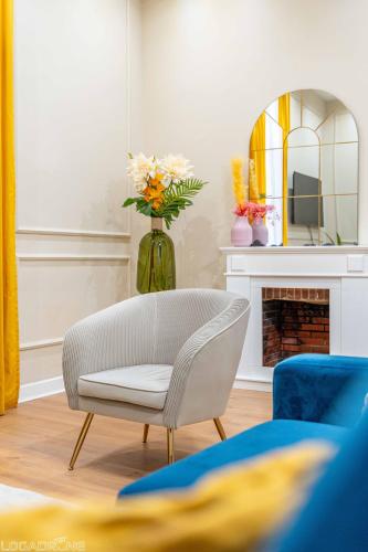 - un salon avec une chaise et un vase fleuri dans l'établissement Appartement de Prestige Le Saphir - 60m2, à Périgueux