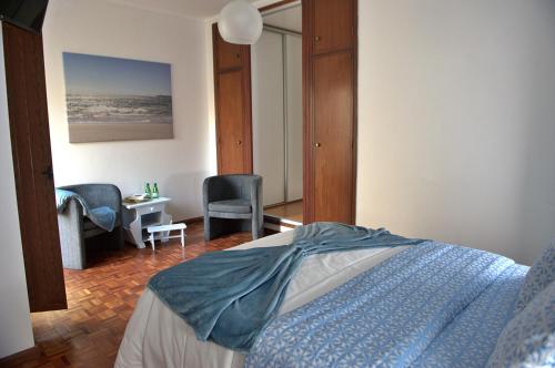 a bedroom with a bed and a desk and chairs at Emunah - no coração de Aveiro in Aveiro