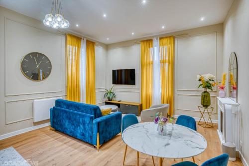 un salon avec un canapé bleu et une table dans l'établissement Appartement de Prestige Le Saphir - 60m2, à Périgueux