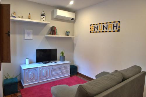 ein Wohnzimmer mit Sofa und Fernseher in der Unterkunft Emunah - no coração de Aveiro in Aveiro