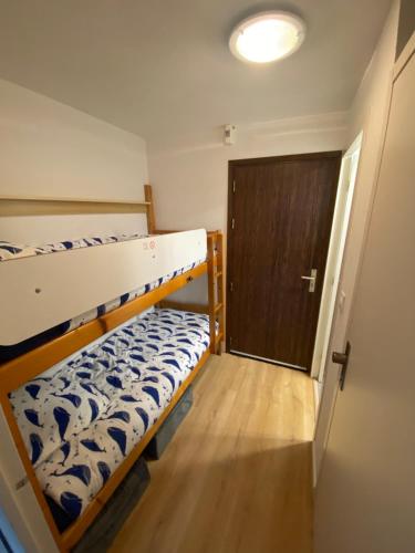 Cette chambre comprend 2 lits superposés et une porte. dans l'établissement Meublé La Baule Plage Benoit, à La Baule