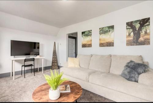 a living room with a white couch and a table at Oakwoods 1BR Suite in Bankview in Calgary