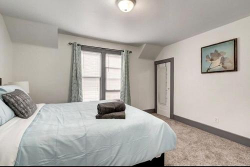 a bedroom with a white bed and a window at Oakwoods 1BR Suite in Bankview in Calgary
