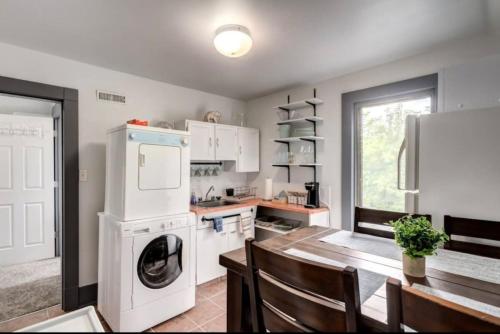 a kitchen with a washer and dryer and a table at Oakwoods 1BR Suite in Bankview in Calgary