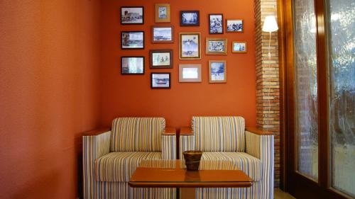 two chairs and a table in a room with pictures on the wall at Hotel Bersoca in Benicàssim