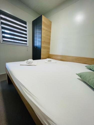 a large white bed in a room with a window at Žaba-Kamp Dalmacija in Privlaka