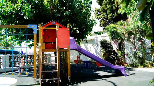 a playground with a purple slide in a yard at Hotel Bersoca in Benicàssim