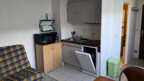 une petite cuisine avec un évier et une cuisinière dans l'établissement Résidence Rond-point-pistes I - Mini studio 19m² 4 pers ROND POINT DES PISTES 1 -N° 122 MAE-7144, à Orcières