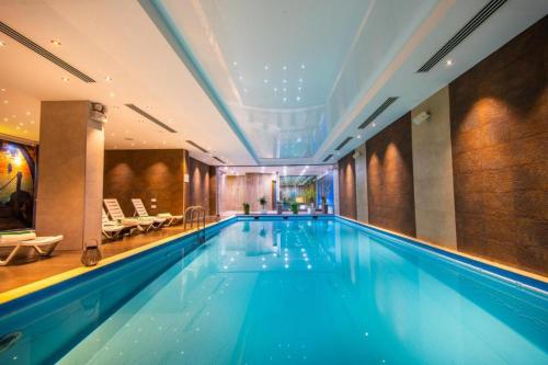 a large swimming pool in a hotel room at ORBI PALACE DeLuxe nice apartment in Bakuriani