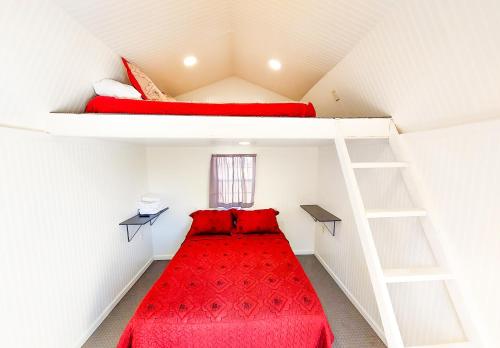 a room with two bunk beds with red sheets at Genas's Sierra Inn & Restaurant in Dunlap