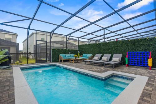 a swimming pool with chairs and a table and a patio at BRAND New 5 bed Villa in Windsor Cay in Orlando
