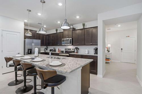 a kitchen with a large island with bar stools at BRAND New 5 bed Villa in Windsor Cay in Orlando