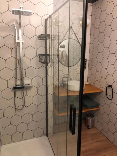 a shower stall with a sink and a mirror at Centre historique de Vitré avec garage in Vitré
