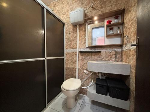 a bathroom with a toilet and a sink and a shower at Bombinhas, Casa, 3 quartos, c piscina em Bombas - SC in Bombinhas