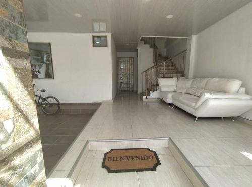 a living room with a couch and a sign on the floor at Apto 202, área mtana de Barranquilla in Soledad