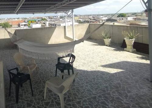 a patio with chairs and a hammock on a roof at Apto 202, área mtana de Barranquilla in Soledad