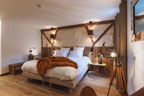 une chambre avec un grand lit avec une couverture marron dans l'établissement Grand Hôtel L'ermitage, à Font-Romeu