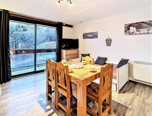 kuchnia i jadalnia z drewnianym stołem i krzesłami w obiekcie Résidence Zodiaque - BEAU STUDIO ALCOVE DE 31M² MAE-6794 w mieście Villarembert