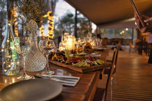 a table with wine glasses and a plate of food at Ooraminna Homestead in Alice Springs