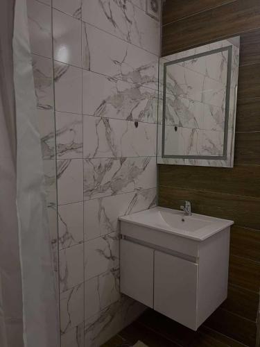 a bathroom with a white sink and a mirror at Umbrella Resort & Villas in Prishtinë