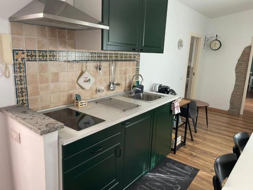 a kitchen with green cabinets and a sink at Il Giardino di Ambra Casa Vacanze indipendente in Viterbo