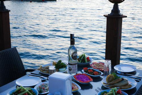 a table with plates of food and a bottle of wine at Club Aquarium Hotel & Spa in Guvercinlik