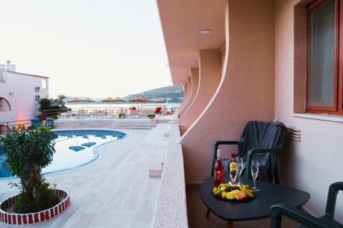 a table with fruit on it next to a pool at Club Aquarium Hotel & Spa in Guvercinlik