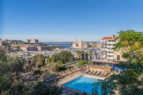 une piscine avec des chaises longues et un bâtiment dans l'établissement Le Pharo, emplacement exceptionnel 2 minutes du vieux port appartement rénové, à Marseille