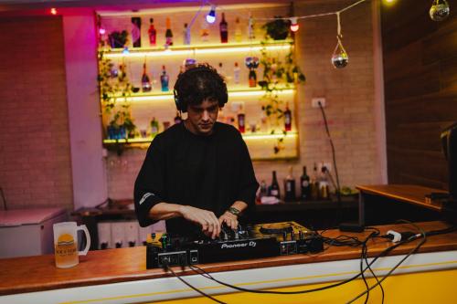 a man standing behind a counter in a bar at Sol e Mar Pousada Surf Bar in Guaratuba