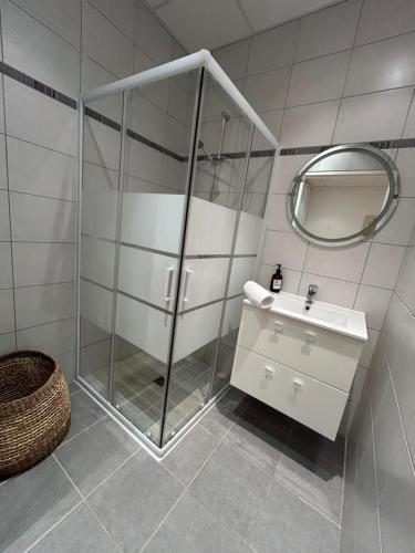 a bathroom with a shower and a sink and a mirror at La Belle Echappée Pyrénéenne in Lourdes
