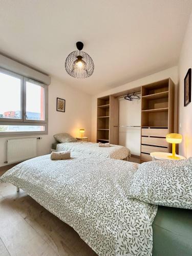 une chambre avec deux lits et une grande fenêtre dans l'établissement LEscale des Artistes - Métro - Tramway - Aéroport, à Toulouse