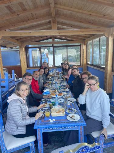 a group of people sitting around a long table at Palacio Del Sol in Chefchaouene