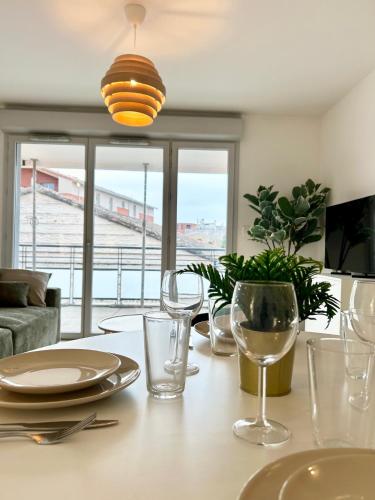 une table de salle à manger avec des verres à vin dessus dans l'établissement LEscale des Artistes - Métro - Tramway - Aéroport, à Toulouse