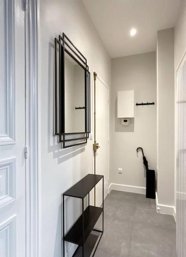une chambre blanche avec une étagère noire et une porte dans l'établissement Champs-Élysées 5 étoiles appartement, à Paris