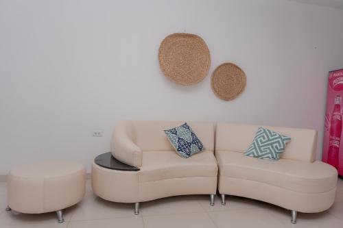 a living room with a couch and a stool at Hotel Aguamarina in Santa Marta