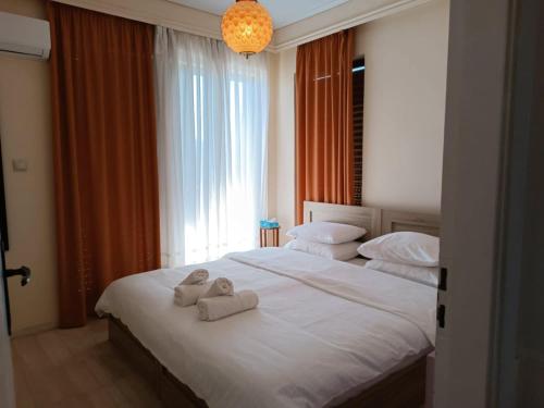 a bedroom with two towels on a bed with a window at Amazing Sea View, Rafina Port, Athens Airport, Self-Check-in in Rafina