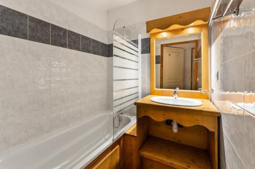 une salle de bain avec un lavabo, une baignoire et un miroir dans l'établissement Résidence Les Hauts De Preclaux - Grand duplex pour 8 couchages MAE-3761, aux Orres