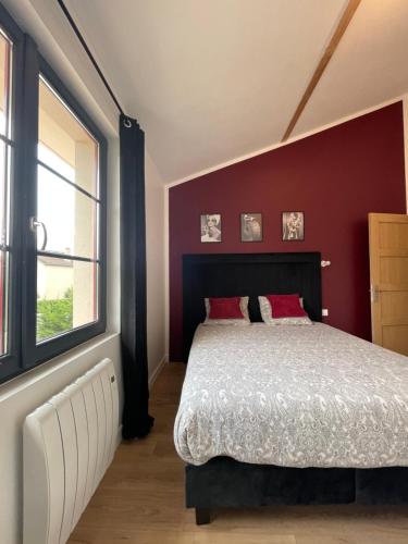 - une chambre dotée d'un lit avec un mur rouge dans l'établissement Maison avec Jacuzzi privé, à Perrigny-lès-Dijon