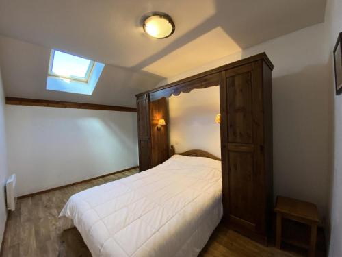 une chambre avec un lit avec une tête de lit en bois et une fenêtre dans l'établissement Résidence Les Hauts De Preclaux - Spacieux 3 pièces et vue imprenable sur les pistes MAE-8231, aux Orres