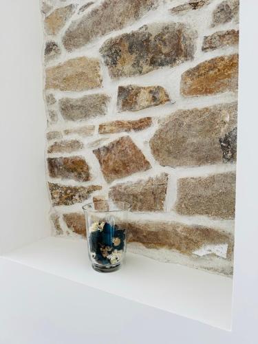 a glass sitting on a table in front of a stone wall at Résidence des Quais - Centre ville - Wifi - Netflix in Quimper