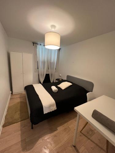 - une chambre avec un lit noir et une table dans l'établissement Le Phoenix, proche stations ski et Campus Univers., à Gières