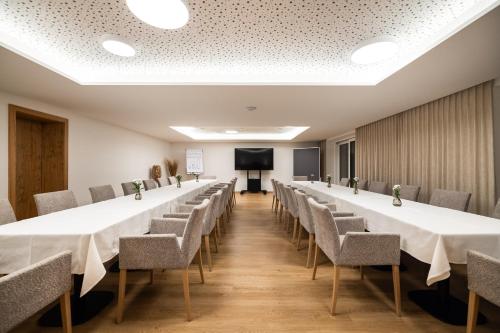 a row of tables and chairs in a room with a screen at Hotel Hubertus in Sankt Johann im Pongau