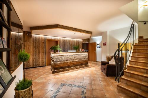a lobby with a stone counter and stairs at Hotel Hubertus in Sankt Johann im Pongau