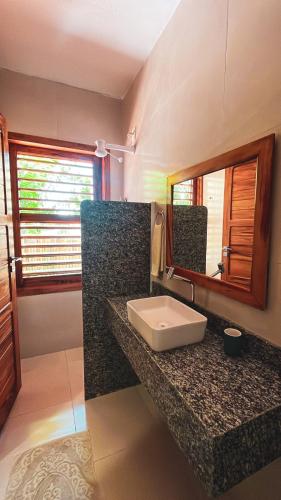 a bathroom with a sink and a mirror at Pousada Casa de Hóspedes in Icaraí