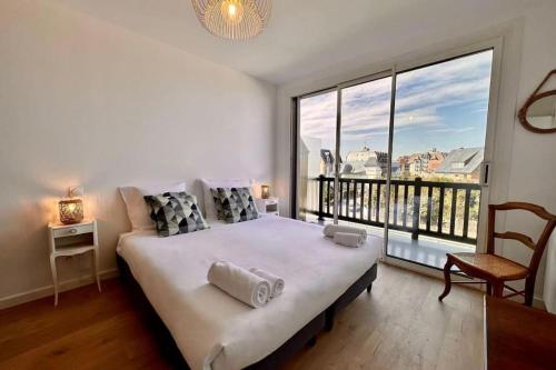 une chambre avec un grand lit et une grande fenêtre dans l'établissement Les Forges-F2 front de mer-4 pers, wifi & parking, à Blonville-sur-Mer